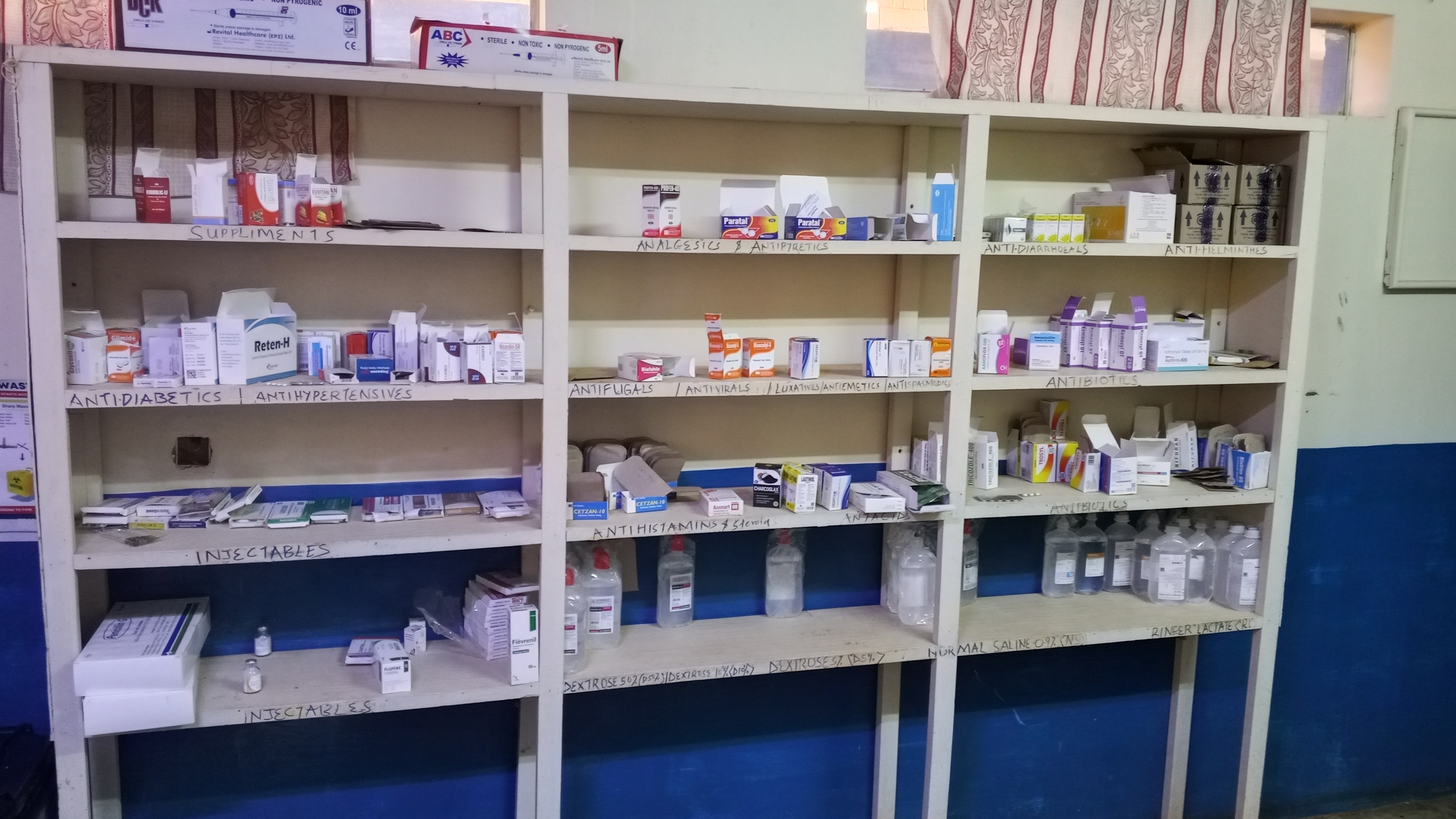 Well-stocked pharmacy at Mwihila Mission Hospital with organized medicine shelves